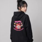 Back view of a woman wearing the black Distracted Puddy Tat raglan hoodie by Keanu Organics