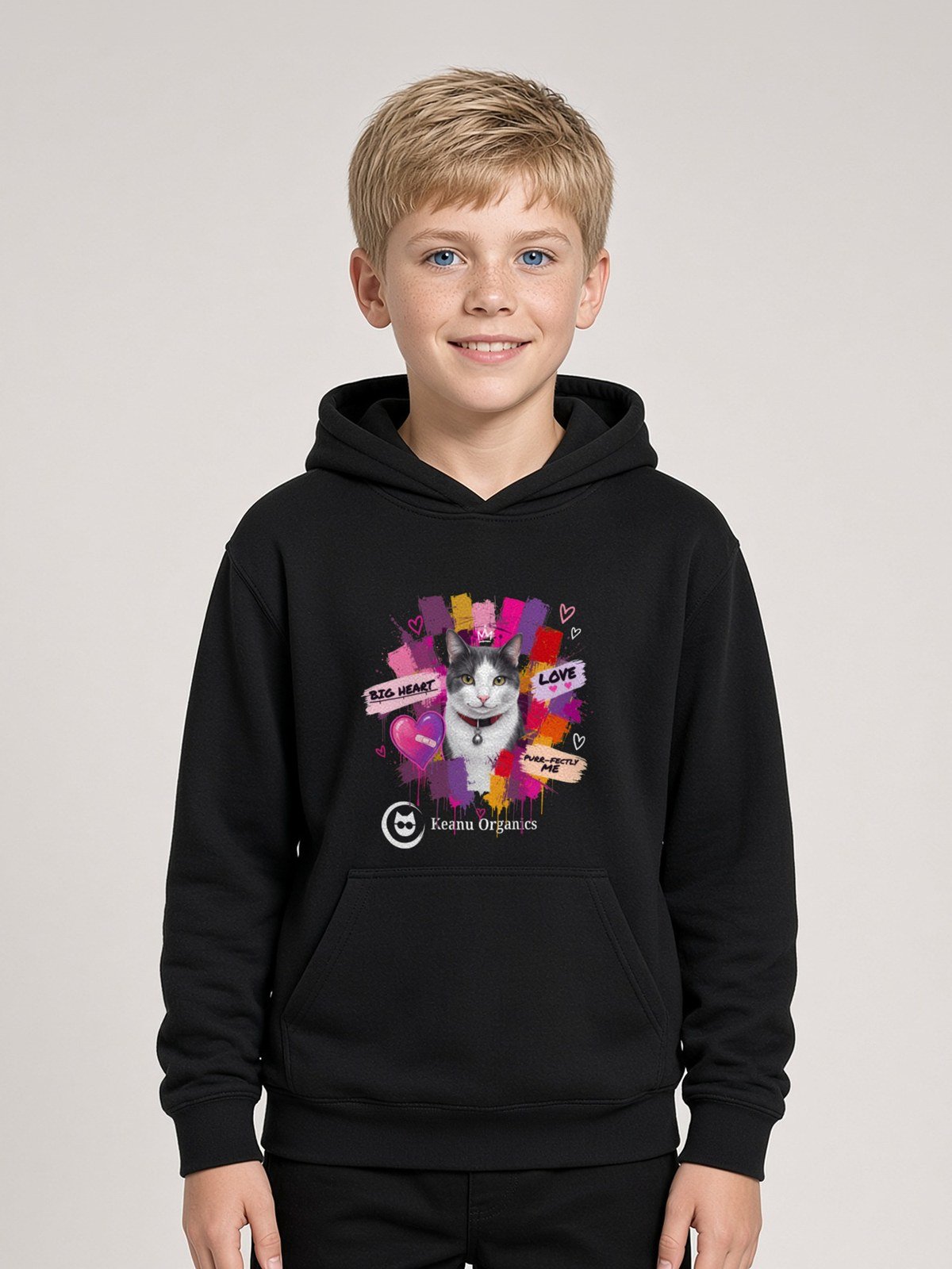 Boy wearing the black Purr-fectly Me Hoodie with Keanu in a crown and paint splashes on the front