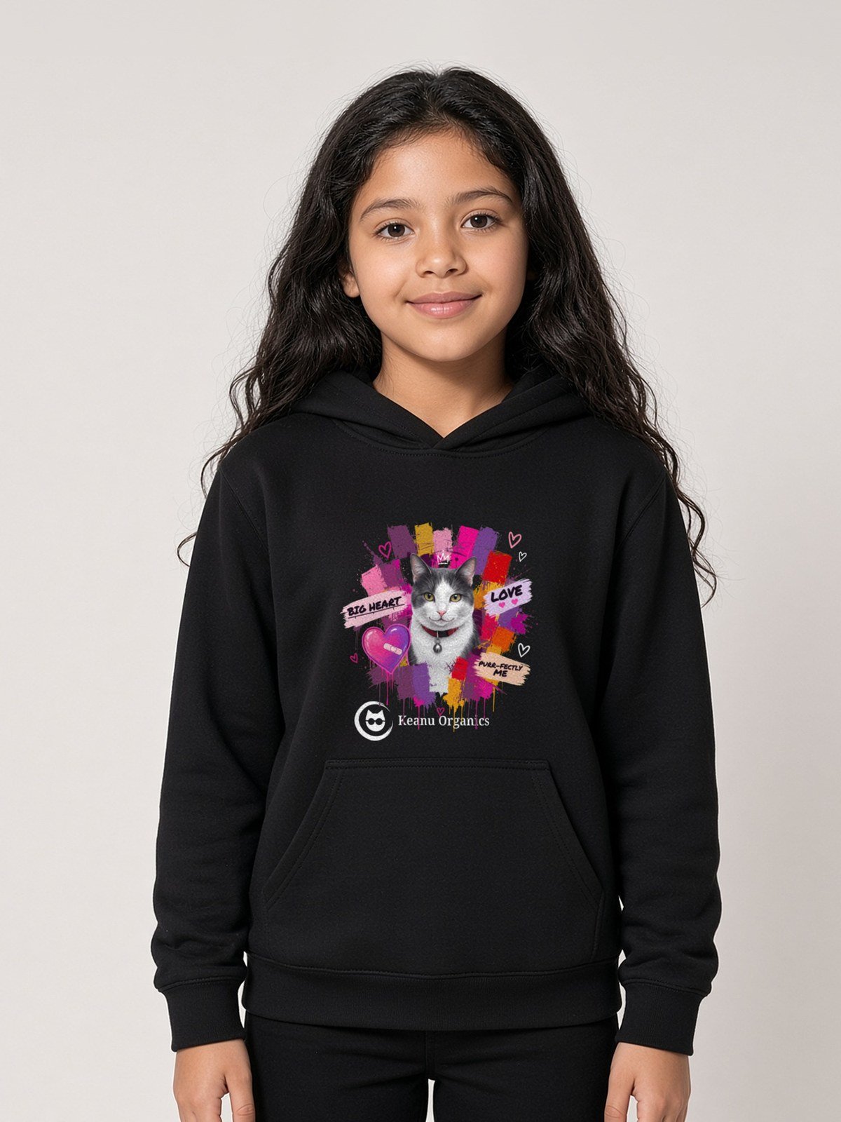 Girl wearing the black Purr-fectly Me Hoodie with Keanu in a crown and paint splashes on the front